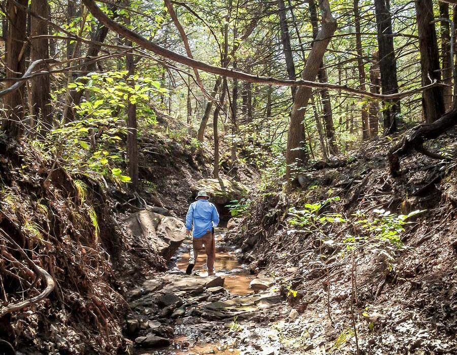 man walking in water valley at Glass Mountain pipeline